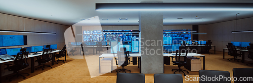 Image of Empty interior of big modern security system control room, workstation with multiple displays, monitoring room with at security data center Empty office, desk, and chairs at a main CCTV security data