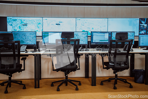 Image of Empty interior of big modern security system control room, workstation with multiple displays, monitoring room with at security data center Empty office, desk, and chairs at a main CCTV security data