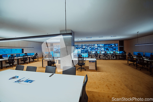 Image of Empty interior of big modern security system control room, workstation with multiple displays, monitoring room with at security data center Empty office, desk, and chairs at a main CCTV security data