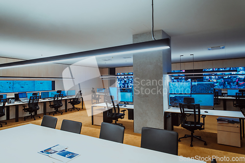 Image of Empty interior of big modern security system control room, workstation with multiple displays, monitoring room with at security data center Empty office, desk, and chairs at a main CCTV security data