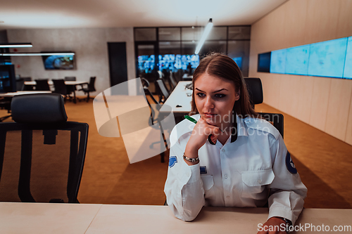 Image of Female security operator working in a data system control room offices Technical Operator Working at workstation with multiple displays, security guard working on multiple monitors