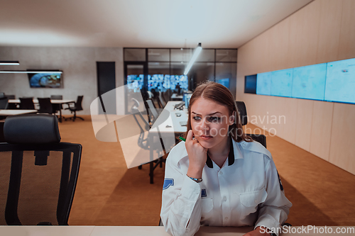 Image of Female security operator working in a data system control room offices Technical Operator Working at workstation with multiple displays, security guard working on multiple monitors