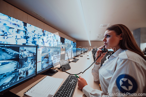 Image of Female security operator working in a data system control room offices Technical Operator Working at workstation with multiple displays, security guard working on multiple monitors