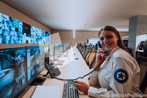 Image of Female security operator working in a data system control room offices Technical Operator Working at workstation with multiple displays, security guard working on multiple monitors