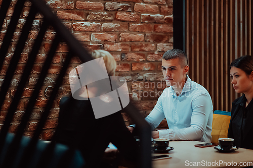 Image of Happy businesspeople smiling cheerfully during a meeting in a coffee shop. Group of successful business professionals working as a team in a multicultural workplace.