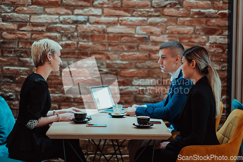 Image of Happy businesspeople smiling cheerfully during a meeting in a coffee shop. Group of successful business professionals working as a team in a multicultural workplace.