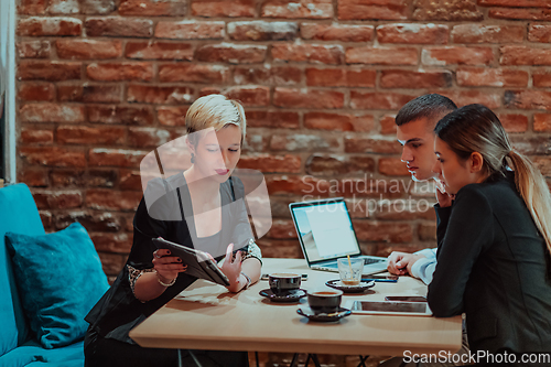 Image of Happy businesspeople smiling cheerfully during a meeting in a coffee shop. Group of successful business professionals working as a team in a multicultural workplace.