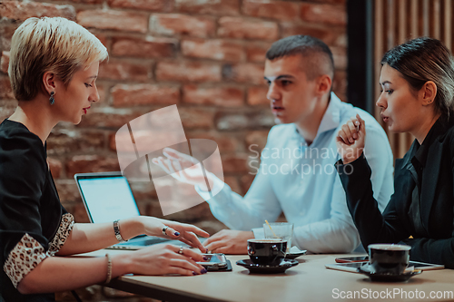 Image of Happy businesspeople smiling cheerfully during a meeting in a coffee shop. Group of successful business professionals working as a team in a multicultural workplace.