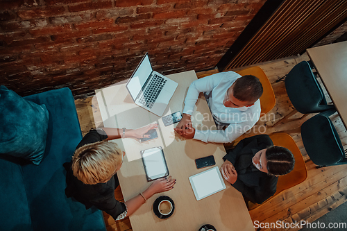 Image of Top view photo of business shaking hands, finishing up meeting. Successful businesspeople handshaking after good deal