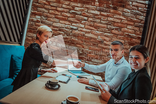 Image of Business shaking hands, finishing up meeting. Successful businesspeople handshaking after good deal