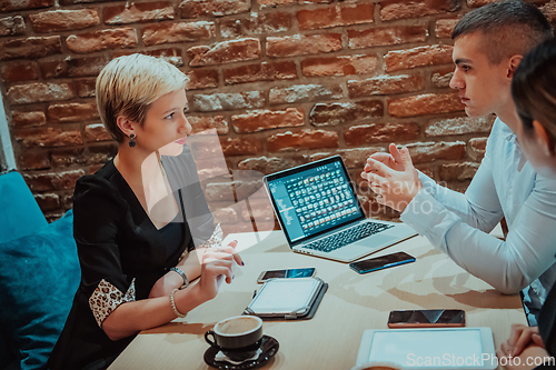 Image of Happy businesspeople smiling cheerfully during a meeting in a coffee shop. Group of successful business professionals working as a team in a multicultural workplace.