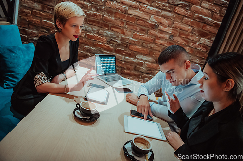 Image of Happy businesspeople smiling cheerfully during a meeting in a coffee shop. Group of successful business professionals working as a team in a multicultural workplace.