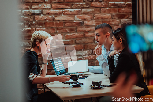 Image of Happy businesspeople smiling cheerfully during a meeting in a coffee shop. Group of successful business professionals working as a team in a multicultural workplace.