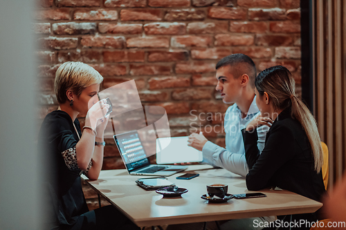 Image of Happy businesspeople smiling cheerfully during a meeting in a coffee shop. Group of successful business professionals working as a team in a multicultural workplace.