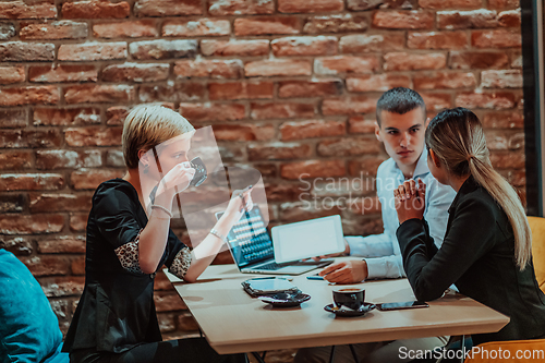 Image of Happy businesspeople smiling cheerfully during a meeting in a coffee shop. Group of successful business professionals working as a team in a multicultural workplace.