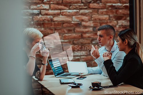 Image of Happy businesspeople smiling cheerfully during a meeting in a coffee shop. Group of successful business professionals working as a team in a multicultural workplace.