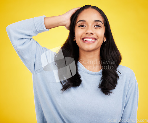 Image of Young woman, hair and beauty, happy in portrait and satisfaction with gen z, fashion on yellow studio background. Happiness, youth and Indian female smile, haircare and cosmetics, growth and shine