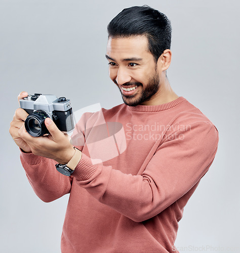 Image of Camera, photography and happy with asian man in studio for photoshoot, satisfaction and creative. Vintage, photographer and production with male on white background for shooting, lens and hobby