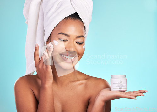 Image of Skincare, lotion and black woman with jar, cream for anti aging and fresh skin glow on blue background. Cosmetics, facial and African model with moisturizer or cleansing product in hand in studio.