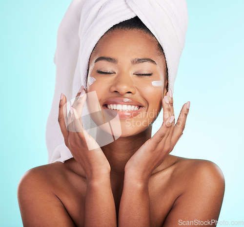 Image of Skincare, beauty and lotion, black woman with smile on face for anti aging or skin glow on blue background. Cosmetics, facial and cream, African model with moisturizer or cleansing product in studio.