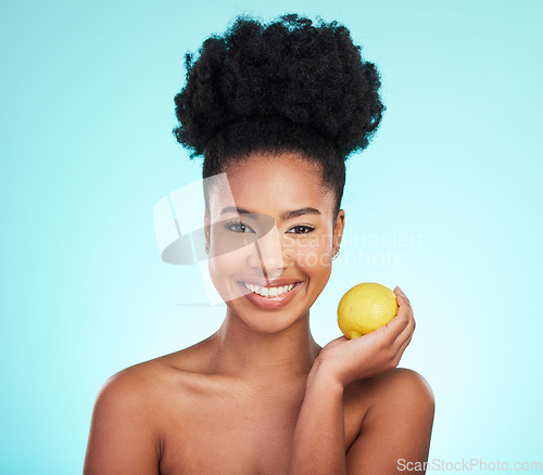 Image of Lemon beauty, portrait and happy black woman in studio, blue background and vegan wellness. Happy model, citrus fruits and smile for facial cosmetics, vitamin c skincare and natural detox dermatology