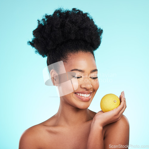 Image of Lemon, skincare happiness and woman with beauty, wellness and detox healthcare. Isolated, blue background and studio with a young female feeling happy from healthy food with vitamin c for glow