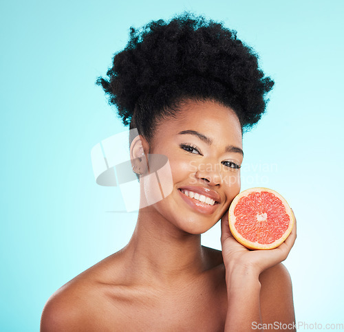 Image of Grapefruit, skincare smile and woman portrait of beauty, wellness and detox healthcare. Isolated, blue background and studio with a female feeling happy from healthy fruit with vitamin c for glow