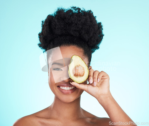 Image of Avocado, happy skincare and woman portrait of beauty, wellness and detox healthcare. Isolated, blue background and studio with a young female smile from healthy fruit food with vitamin for glow