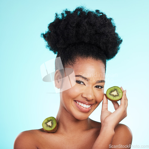 Image of Kiwi fruit, skincare and woman portrait of beauty, wellness and detox healthcare. Isolated, blue background and studio with a young female feeling happy from healthy food with vitamin c for glow