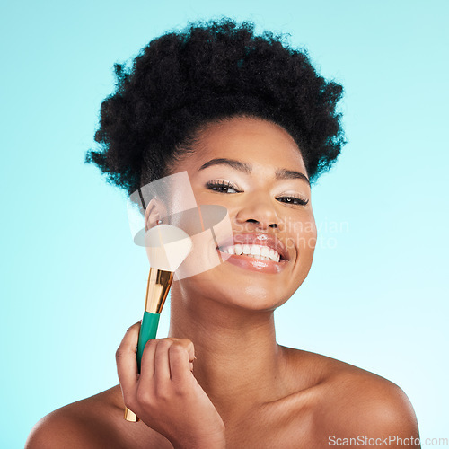 Image of Black woman, brush and foundation in studio with smile for wellness, cosmetics or youth by blue background. Model, girl and african with makeup, powder and happy for skincare, beauty and healthy glow