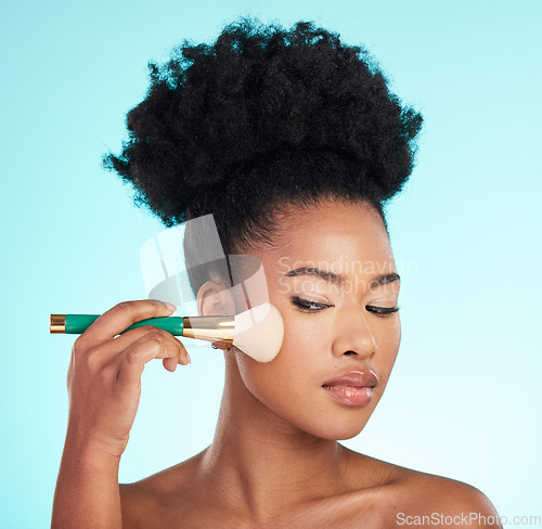 Image of Makeup, cosmetics brush and face of black woman for beauty, glamour and facial treatment on blue background. Salon, cosmetology and girl with brushes for foundation, skincare or application in studio