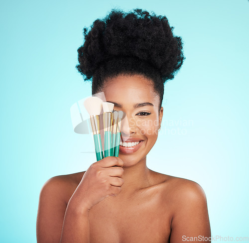 Image of Makeup brushes, cosmetics and portrait of black woman for beauty, glamour and facial on blue background. Salon, cosmetology and face of happy girl for foundation, skincare and application in studio