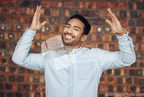 Image of Happy, excited and portrait of asian man and brick wall background for confidence, trendy and natural. Pride, cool and style with male and arms up for laughing, happiness and goofy expression
