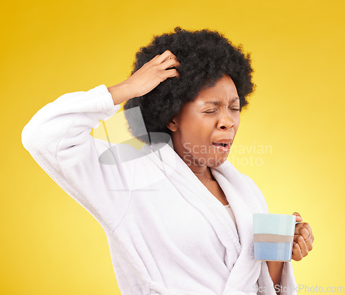 Image of Coffee, yawning and tired black woman in studio, waking up in the morning or sleepy isolated on a yellow background. Exhausted, insomnia and female scratching head with tea or caffeine in bathrobe.