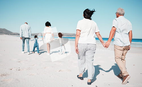 Image of Senior couple, holding hands and family at beach with back for walk, freedom and vacation together with love. Old man, woman and grandchildren by ocean for walking, wellness and adventure in sunshine