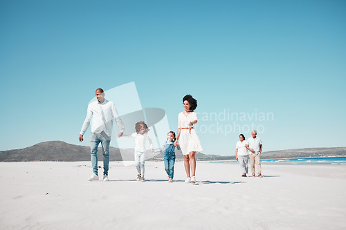 Image of Holding hands, family and children walking on beach to relax on summer holiday, vacation and weekend. Travel, blue sky and grandparents, parents and kids by ocean for fun, bonding and quality time