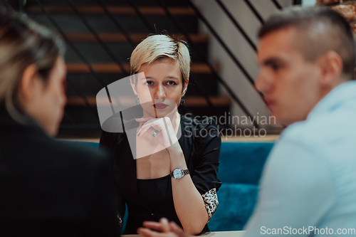 Image of Happy businesspeople smiling cheerfully during a meeting in a coffee shop. Group of successful business professionals working as a team in a multicultural workplace.