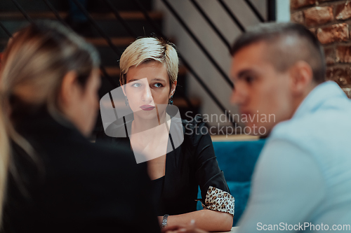 Image of Happy businesspeople smiling cheerfully during a meeting in a coffee shop. Group of successful business professionals working as a team in a multicultural workplace.