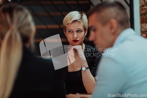 Image of Happy businesspeople smiling cheerfully during a meeting in a coffee shop. Group of successful business professionals working as a team in a multicultural workplace.