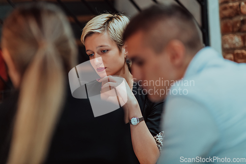 Image of Happy businesspeople smiling cheerfully during a meeting in a coffee shop. Group of successful business professionals working as a team in a multicultural workplace.