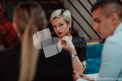 Image of Happy businesspeople smiling cheerfully during a meeting in a coffee shop. Group of successful business professionals working as a team in a multicultural workplace.