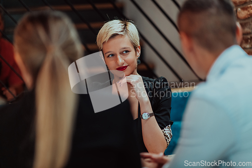 Image of Happy businesspeople smiling cheerfully during a meeting in a coffee shop. Group of successful business professionals working as a team in a multicultural workplace.