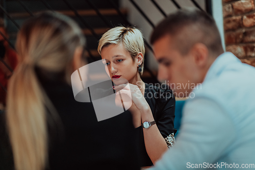 Image of Happy businesspeople smiling cheerfully during a meeting in a coffee shop. Group of successful business professionals working as a team in a multicultural workplace.