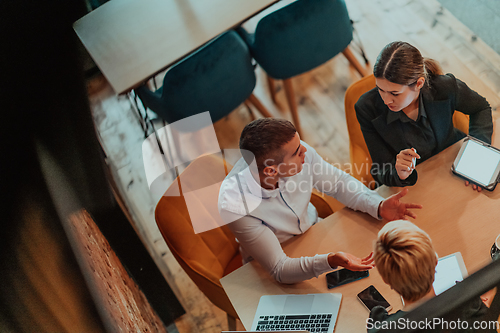 Image of Top view photo of business shaking hands, finishing up meeting. Successful businesspeople handshaking after good deal