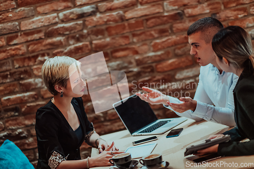 Image of Happy businesspeople smiling cheerfully during a meeting in a coffee shop. Group of successful business professionals working as a team in a multicultural workplace.