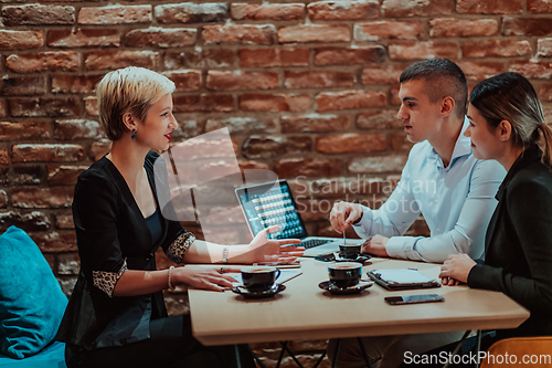 Image of Happy businesspeople smiling cheerfully during a meeting in a coffee shop. Group of successful business professionals working as a team in a multicultural workplace.