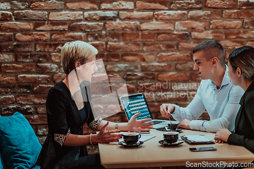 Image of Happy businesspeople smiling cheerfully during a meeting in a coffee shop. Group of successful business professionals working as a team in a multicultural workplace.