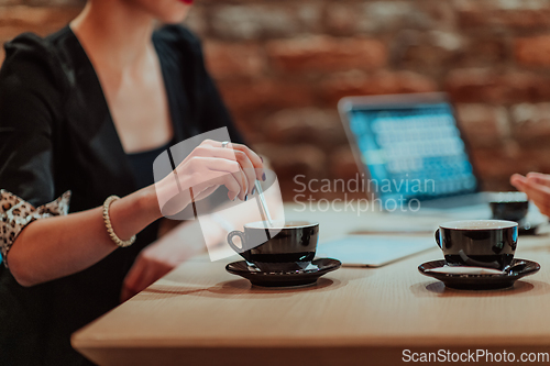 Image of Happy businesspeople smiling cheerfully during a meeting in a coffee shop. Group of successful business professionals working as a team in a multicultural workplace.