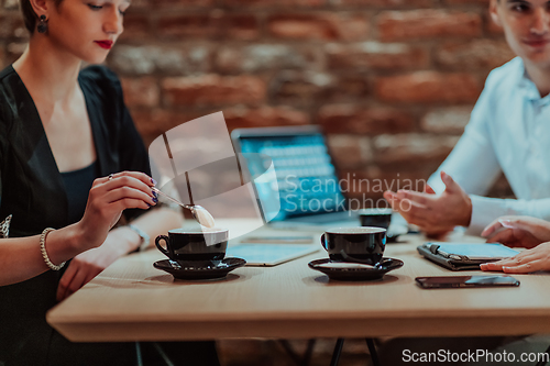 Image of Happy businesspeople smiling cheerfully during a meeting in a coffee shop. Group of successful business professionals working as a team in a multicultural workplace.