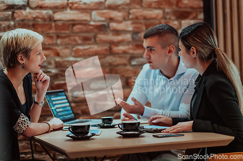 Image of Happy businesspeople smiling cheerfully during a meeting in a coffee shop. Group of successful business professionals working as a team in a multicultural workplace.